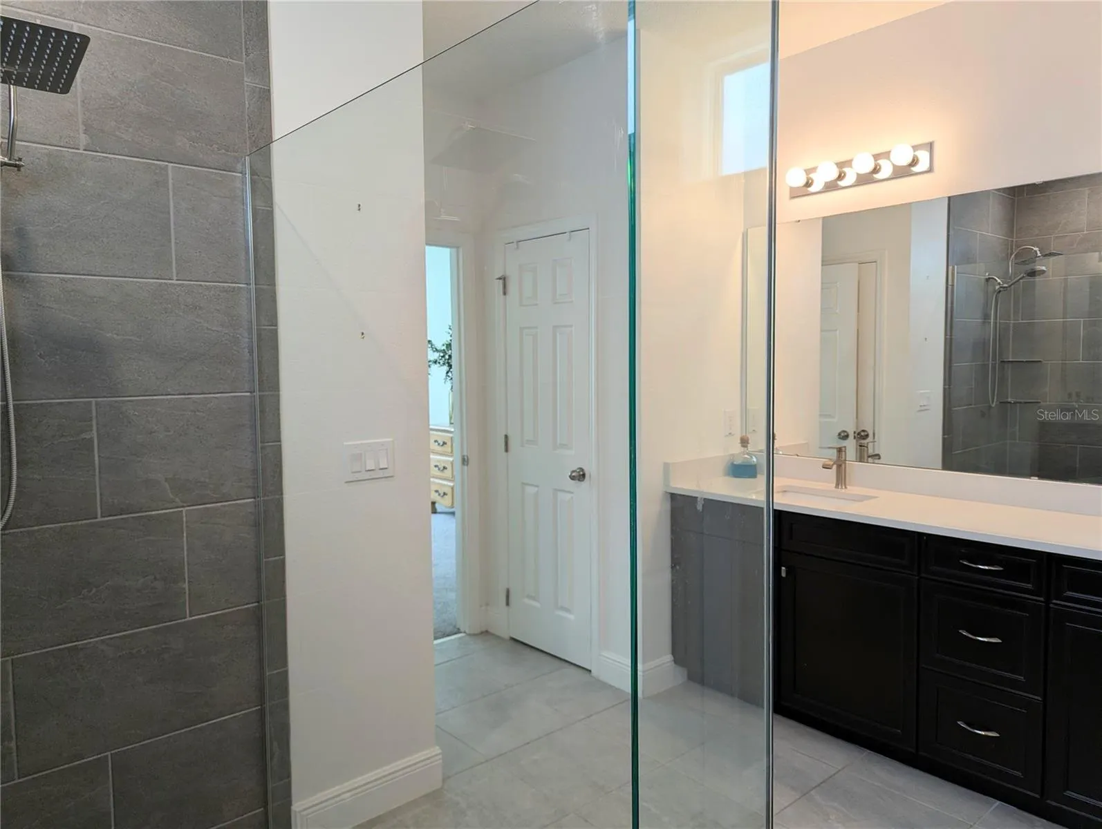 Huge walk in shower with river rock and a rain shower head.