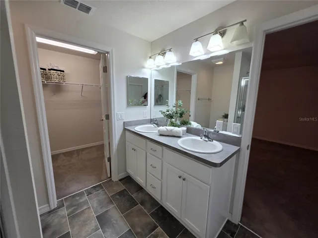 Primary bathroom with 2 sinks and large walk in closet