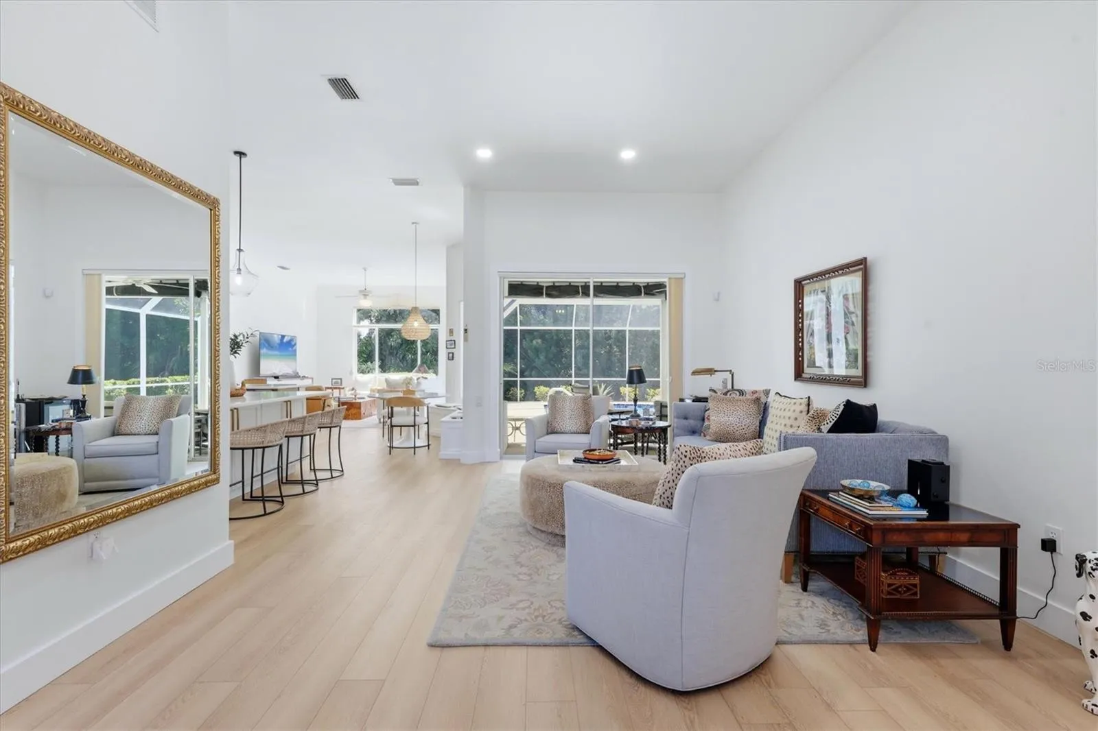 Living room at entry, sliders open to pool.