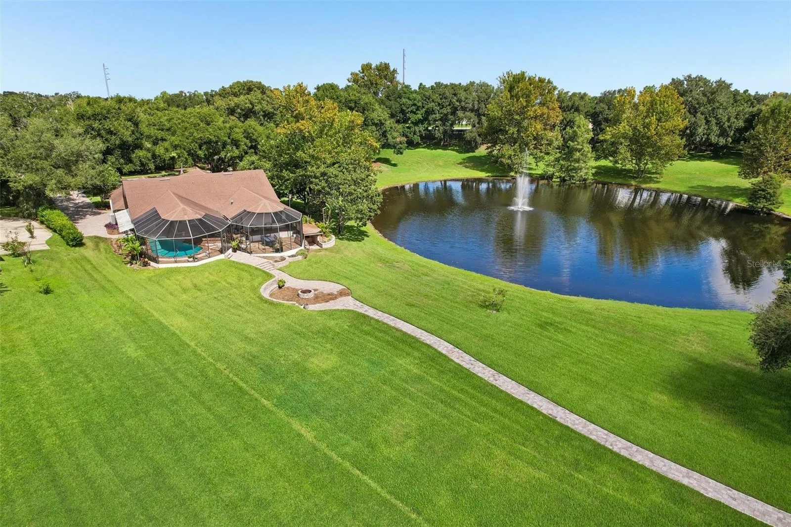 Expansive back yard with paver walkway down to the dock.