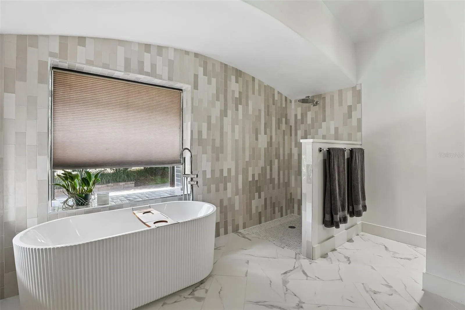 New primary bathroom with zero entry frameless shower and freestanding tub.