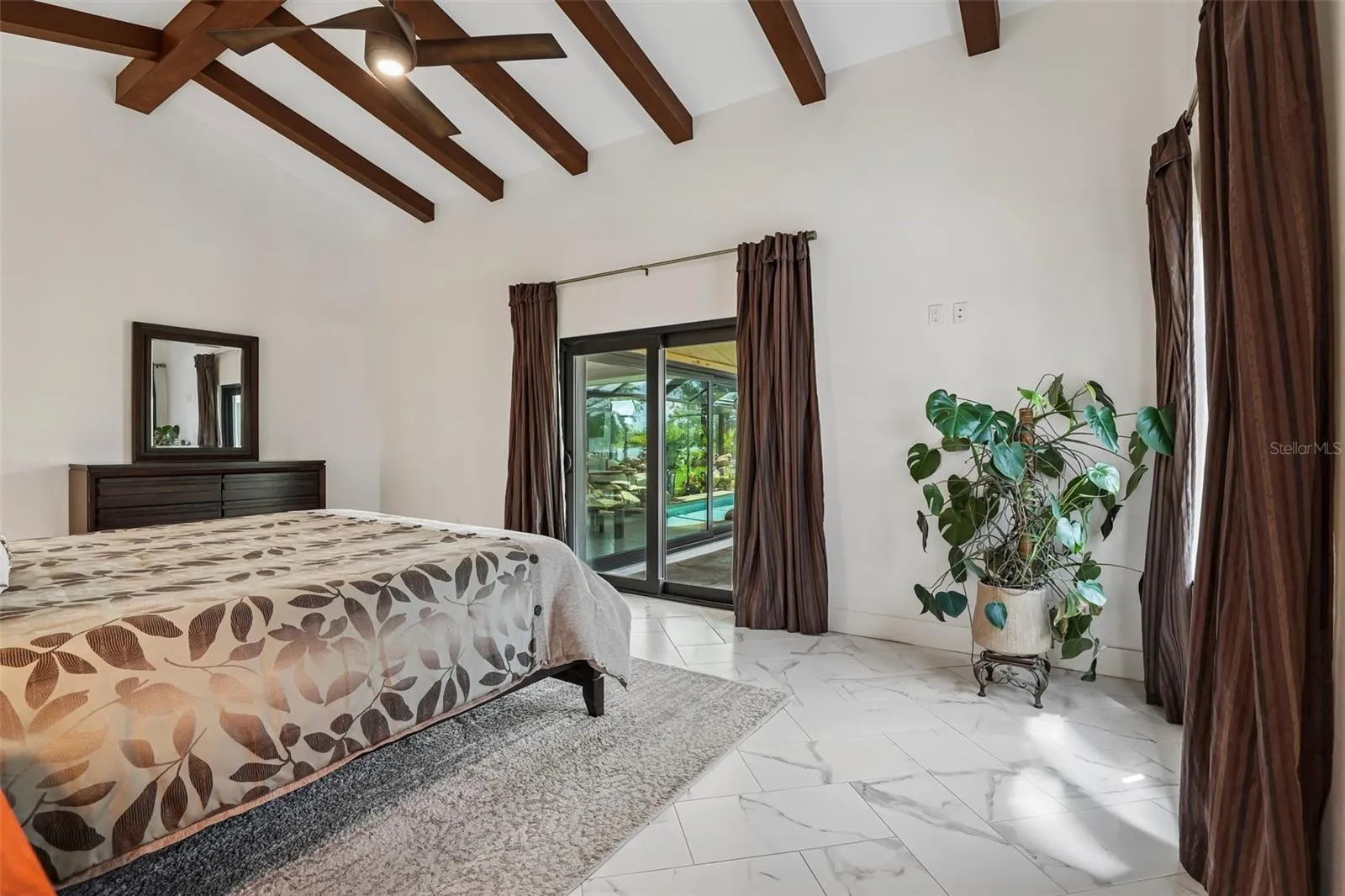 Primary bedroom with views of the lake and opening onto the lanai.