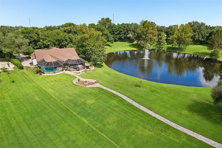 Expansive back yard with paver walkway down to the dock.
