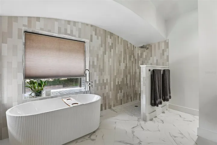 New primary bathroom with zero entry frameless shower and freestanding tub.