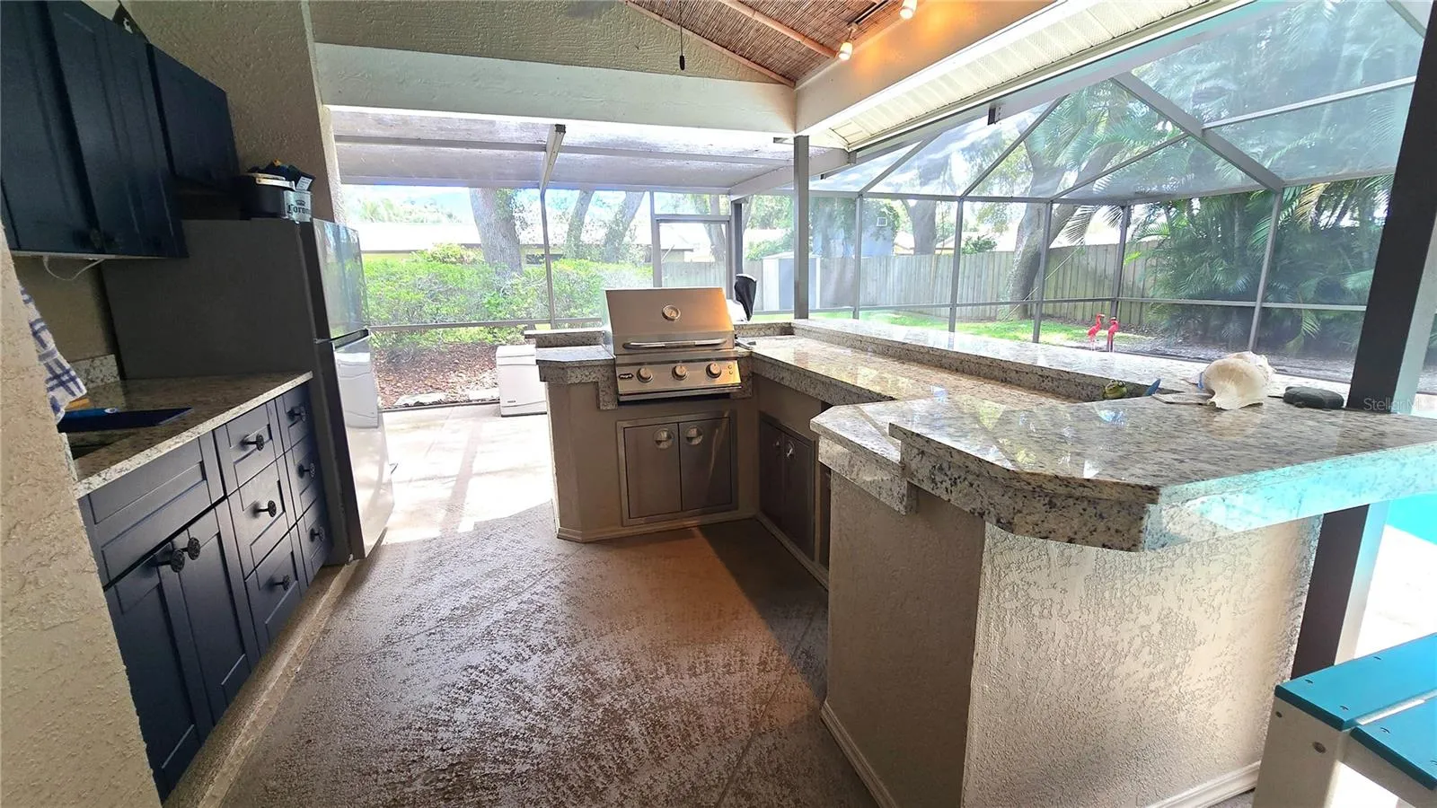 Like to party?  Host all the parties here with this outdoor kitchen area with a built in bar-b-que, cabinets and sit up bar area.