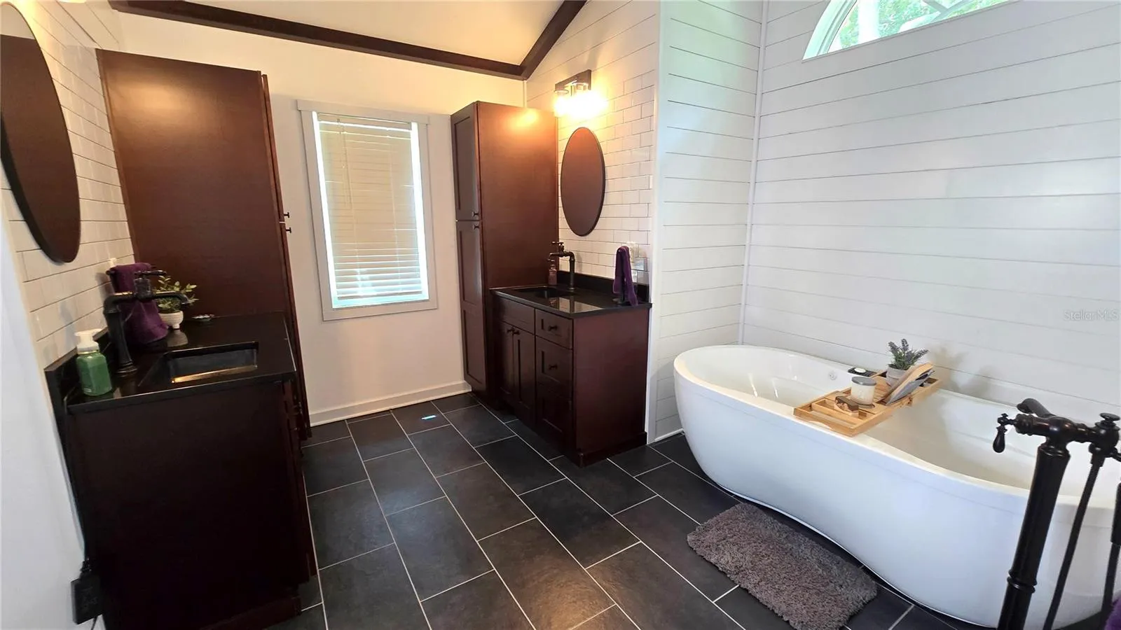 Primary Bathroom with 2 cabinets/vanity.  Don't overlook this adorable tub to relax in after a hard day at work.