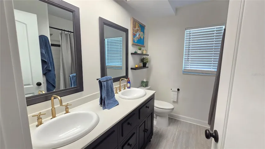 Full bathroom with shower/tub combo plus double sinks.