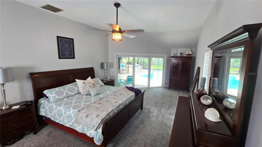 This primary suite bedroom has its own personal access through the sliding glass doors to enter the pool area.  Size of bedroom is approximately 26 x 13 not including the 2 walk-in closets.