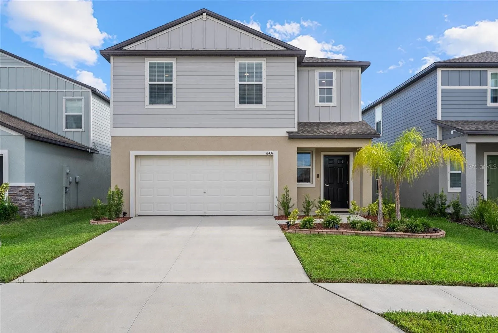Beautiful front elevation enhanced by tropical landscaping and a well-maintained lawn.