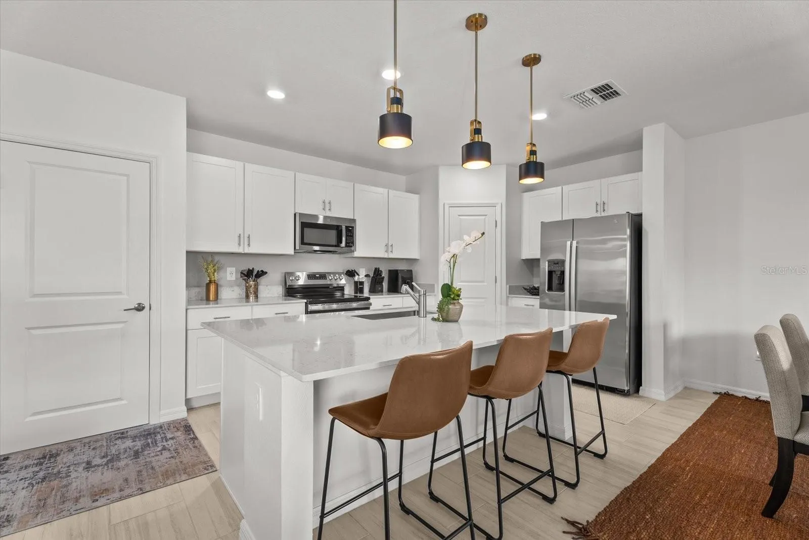 Modern kitchen with a large center island, breakfast seating, and pendant lighting.