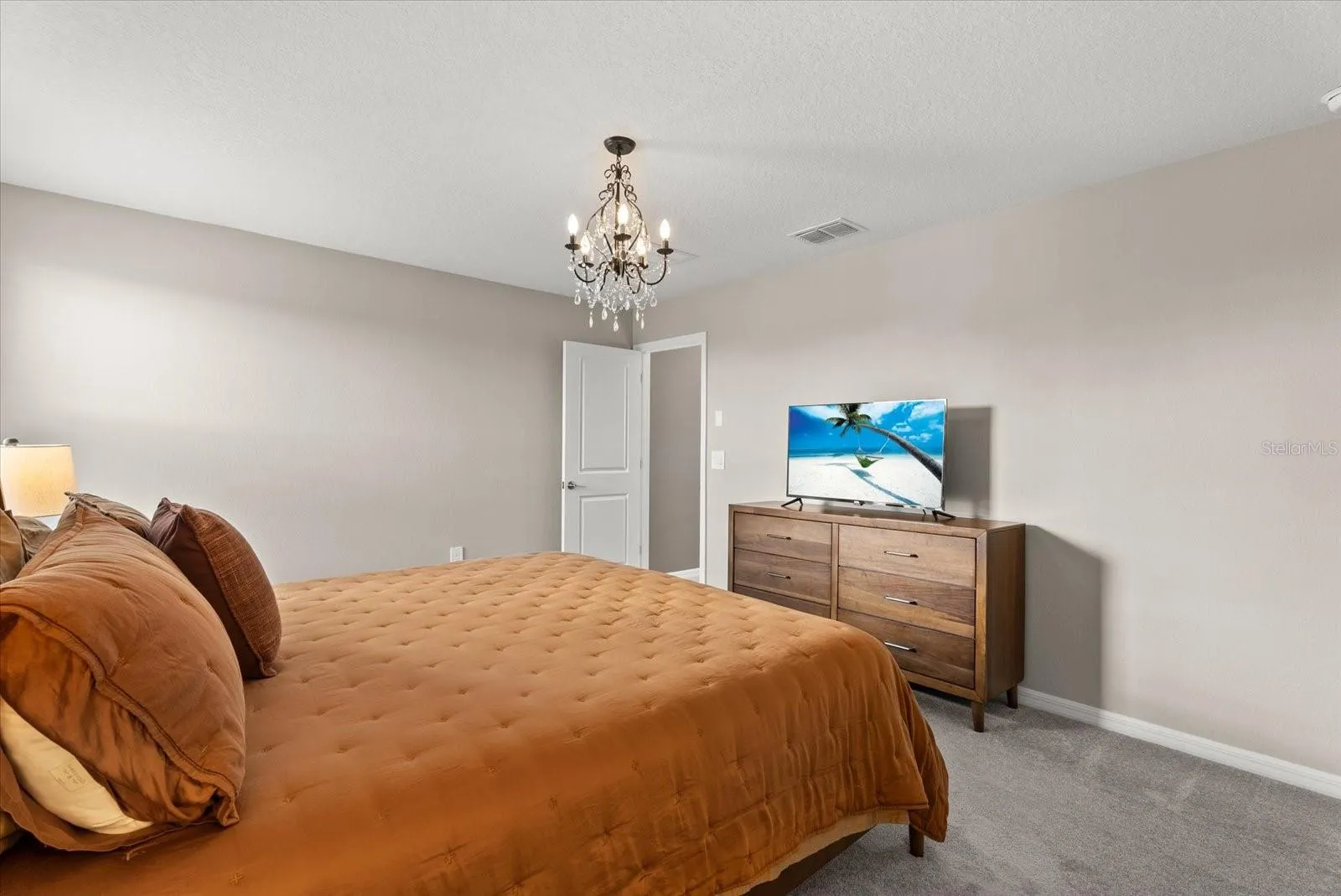 Another view of the spacious primary suite with neutral finishes.