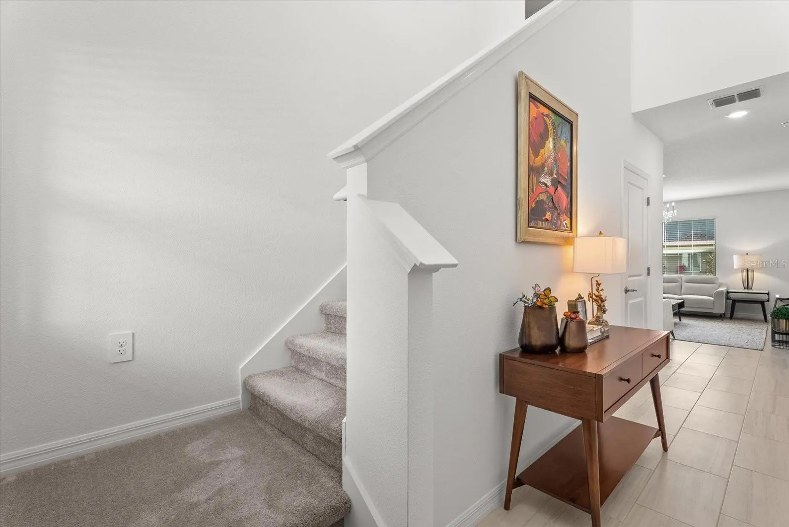 Entryway with carpeted staircase leading to the second floor.