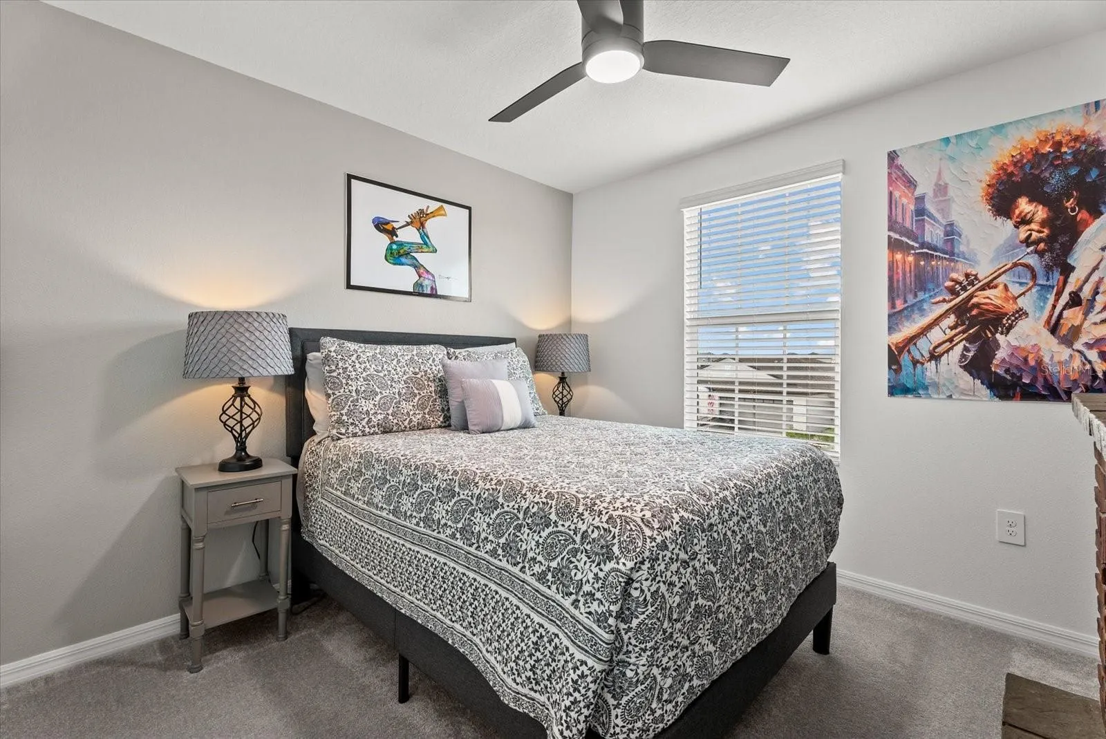 Bright secondary bedroom with ceiling fan, closet, and natural light.