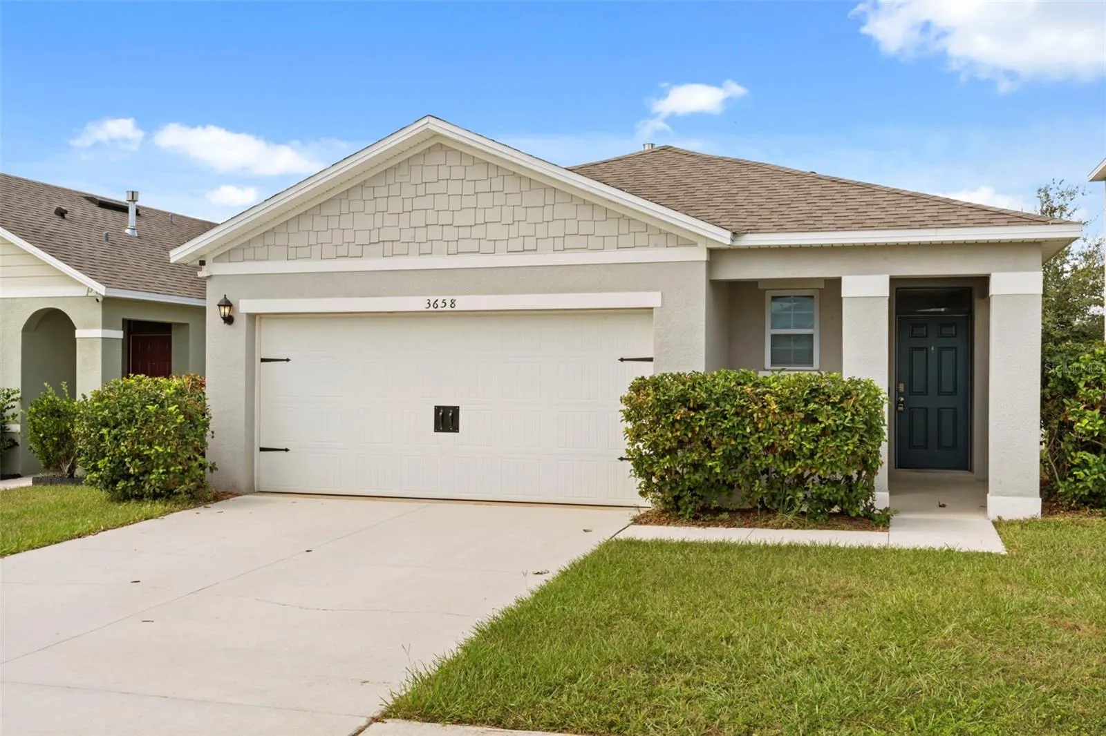 Attractive front elevation with a spacious driveway, 2-car garage, and well-kept landscaping.