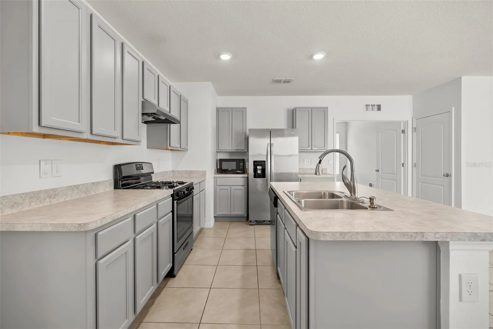 Spacious kitchen featuring stainless steel appliances, generous cabinetry, and ample counter space.