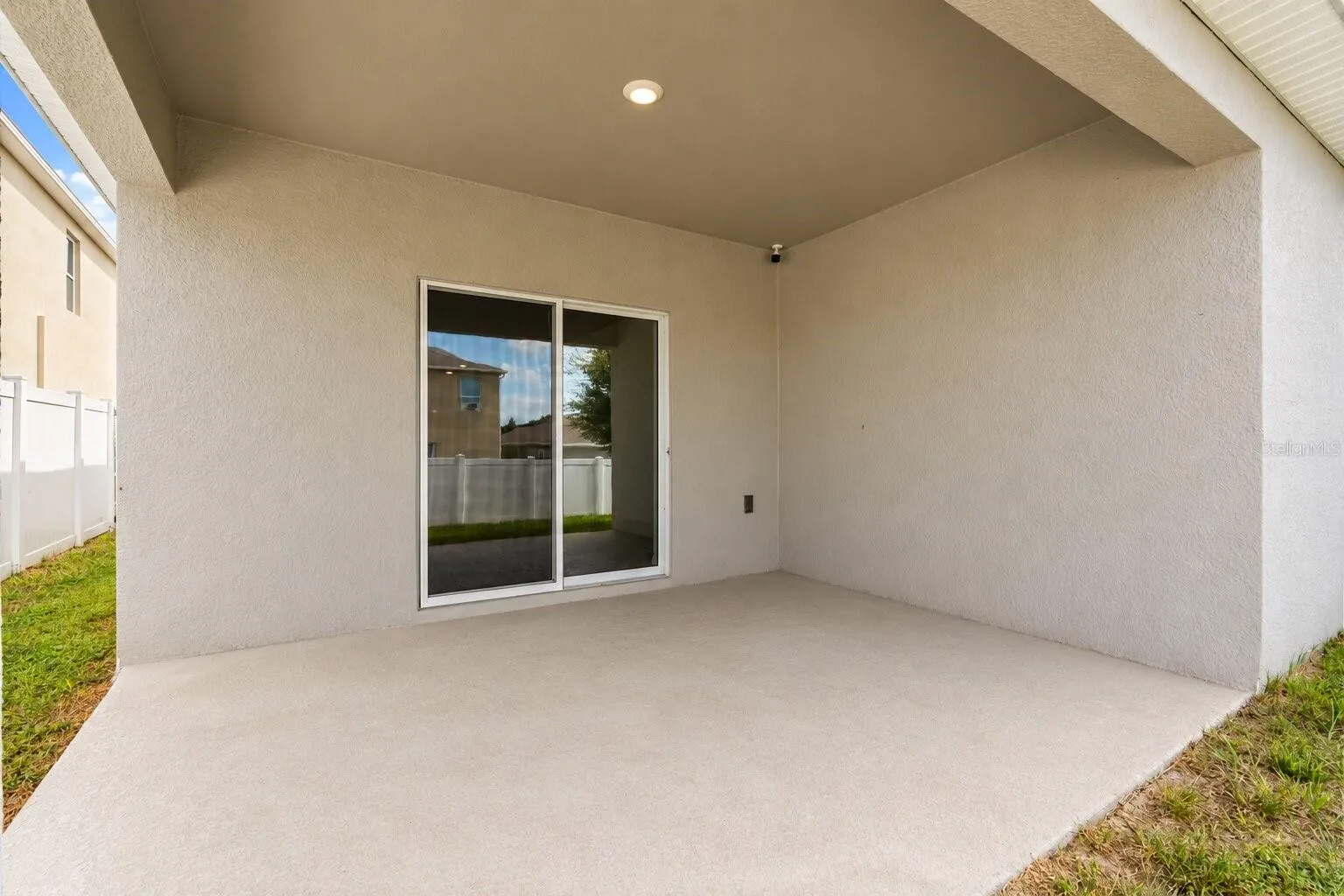 Covered rear lanai offering a shaded space for outdoor dining or relaxing.