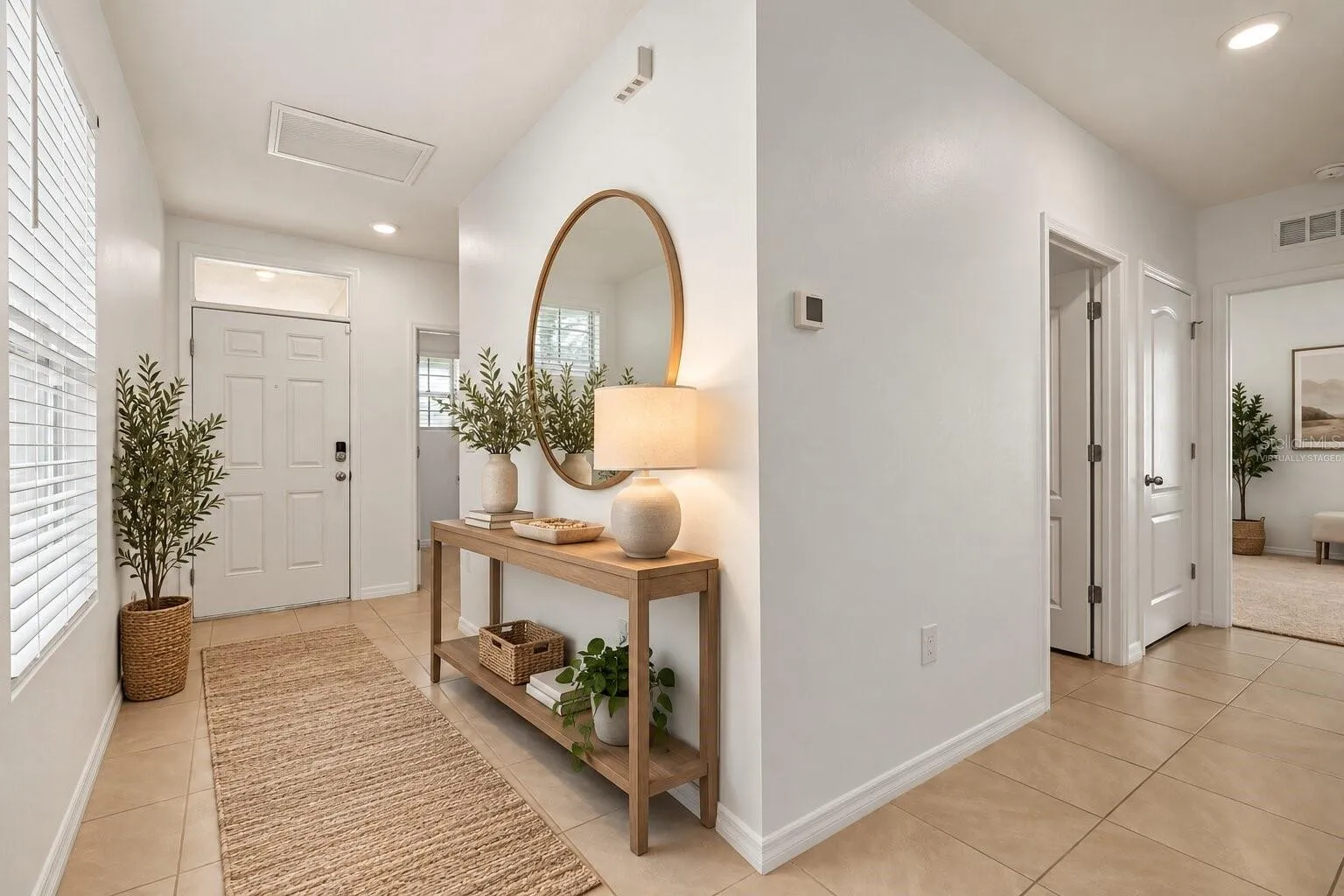 Virtually staged bright, welcoming entryway with neutral finishes and an open, airy feel.