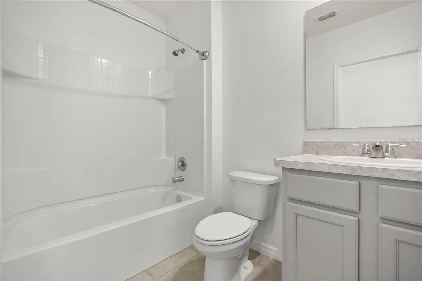 Full guest bathroom with tub/shower combination and vanity.