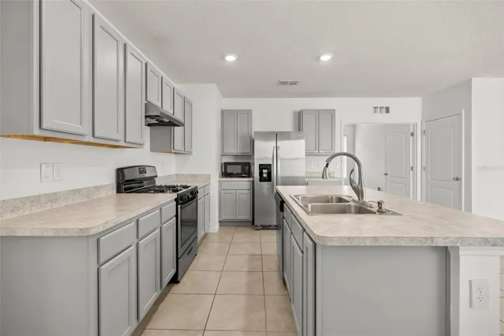 Spacious kitchen featuring stainless steel appliances, generous cabinetry, and ample counter space.