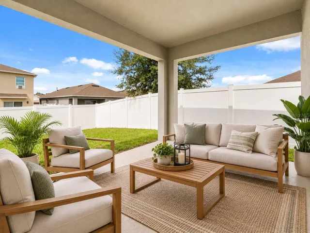 Spacious covered patio overlooking the fenced backyard, virtually staged to showcase the potential for a comfortable outdoor living and entertaining area.