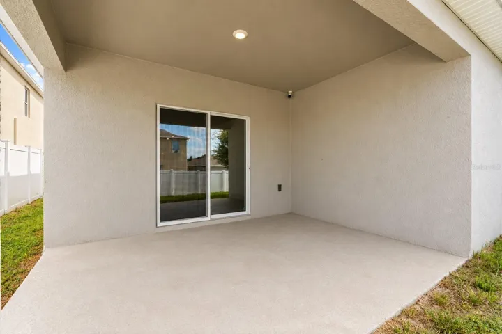 Covered rear lanai offering a shaded space for outdoor dining or relaxing.