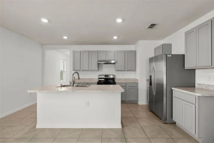 Bright kitchen with stainless steel appliances, abundant cabinetry, and an open layout.