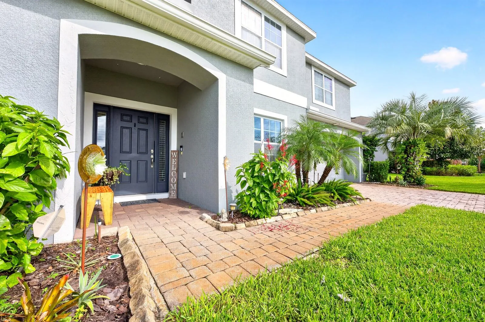 Thoughtful landscaping adds curb appeal, covered front entry.