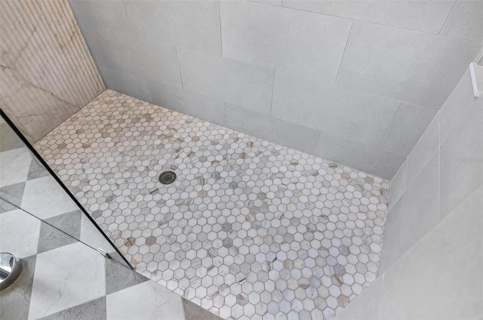 Stunning tiled shower with pebble tile floor and glass