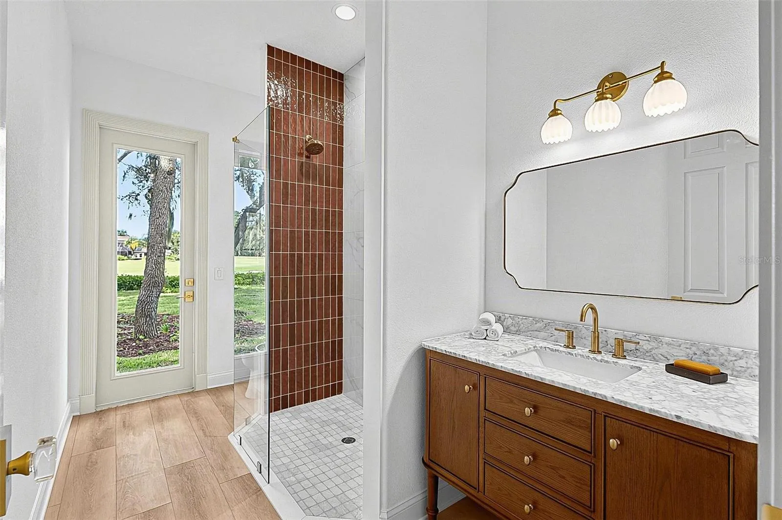 Guest 2nd bathroom with tile shower, stone top wood vanity and outside door entrance
