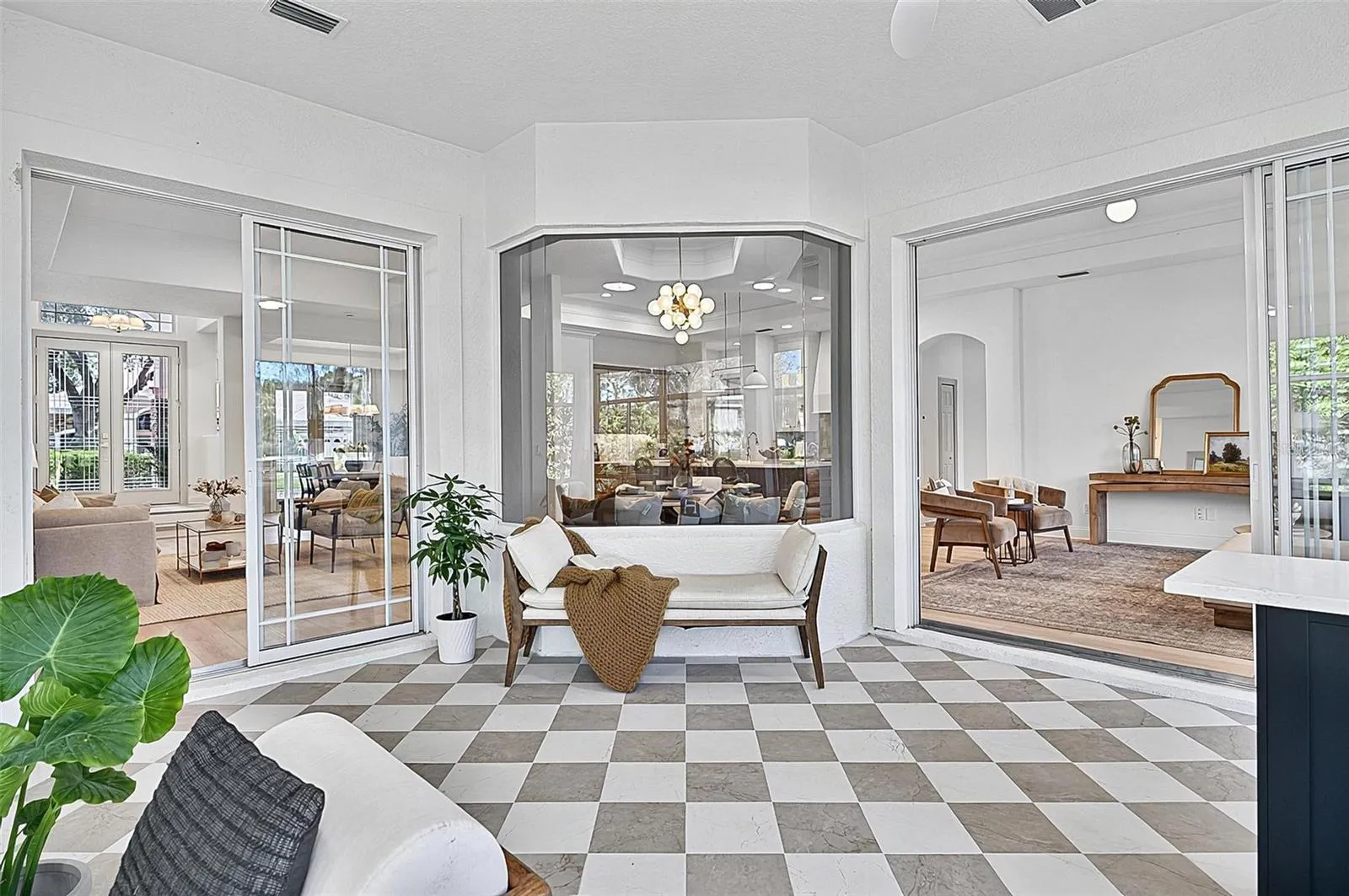 Peaceful Solarium with wall to wall enclosed screened windows looking out on to backyard and golf course. Room is aired and is open to Formal living room and family room