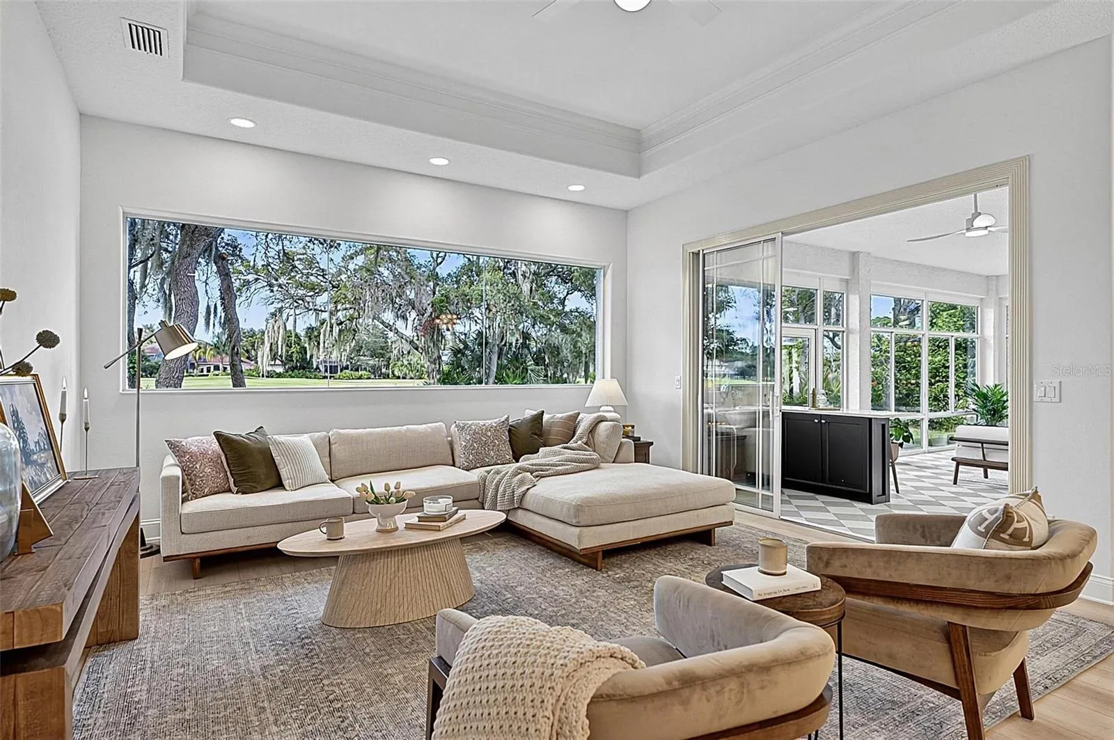 Family room with Stunning views through wall of window looking out to backyard and golf course with triple sliders onto the solarium