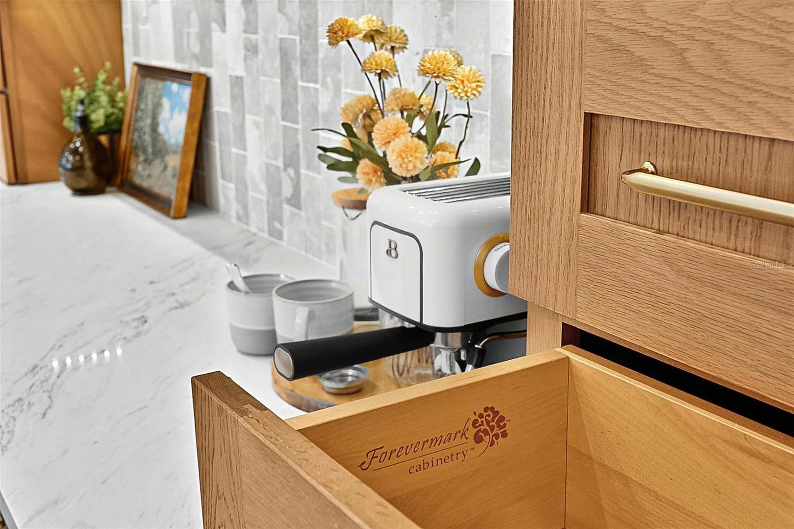 Custom wood soft closing cabinets against under-mount lighting of stunning tile and quartz countertops