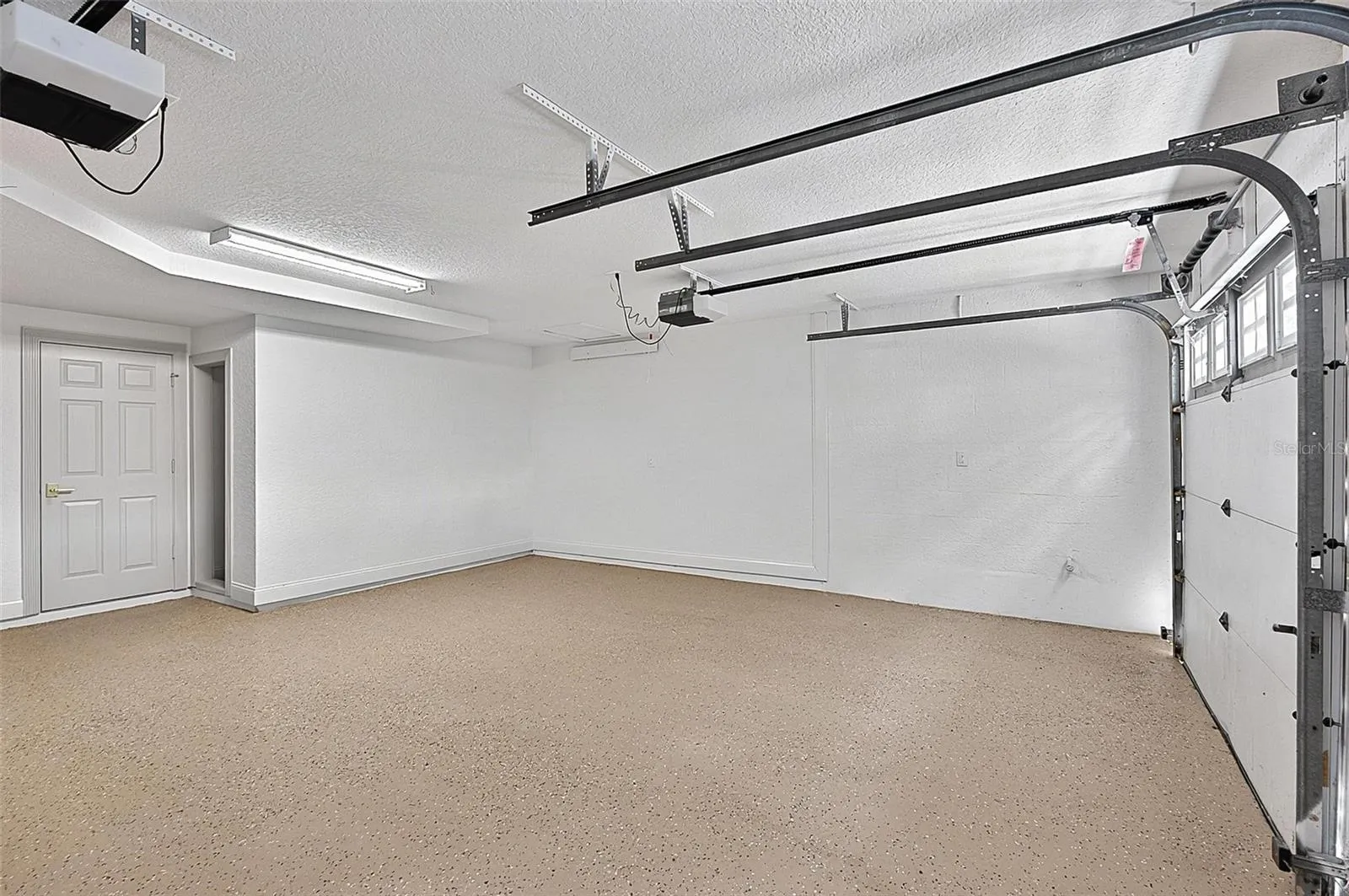 Oversized double door garage with epoxy floor and extra storage area