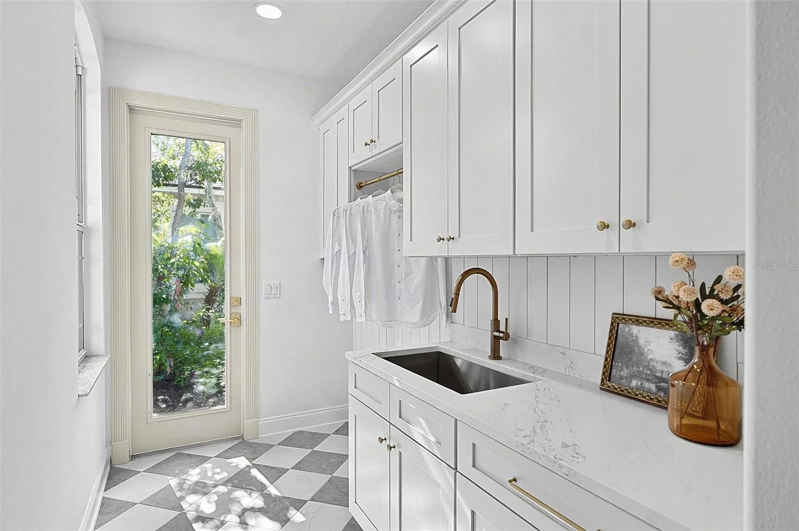Very spacious laundry room, sink, cabinets, quartz countertops and outside entrance