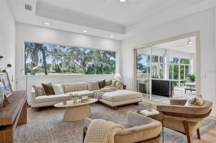 Family room with Stunning views through wall of window looking out to backyard and golf course with triple sliders onto the solarium