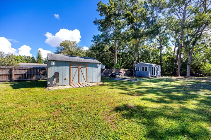 Oversized shed for lawnmower and garden tools.