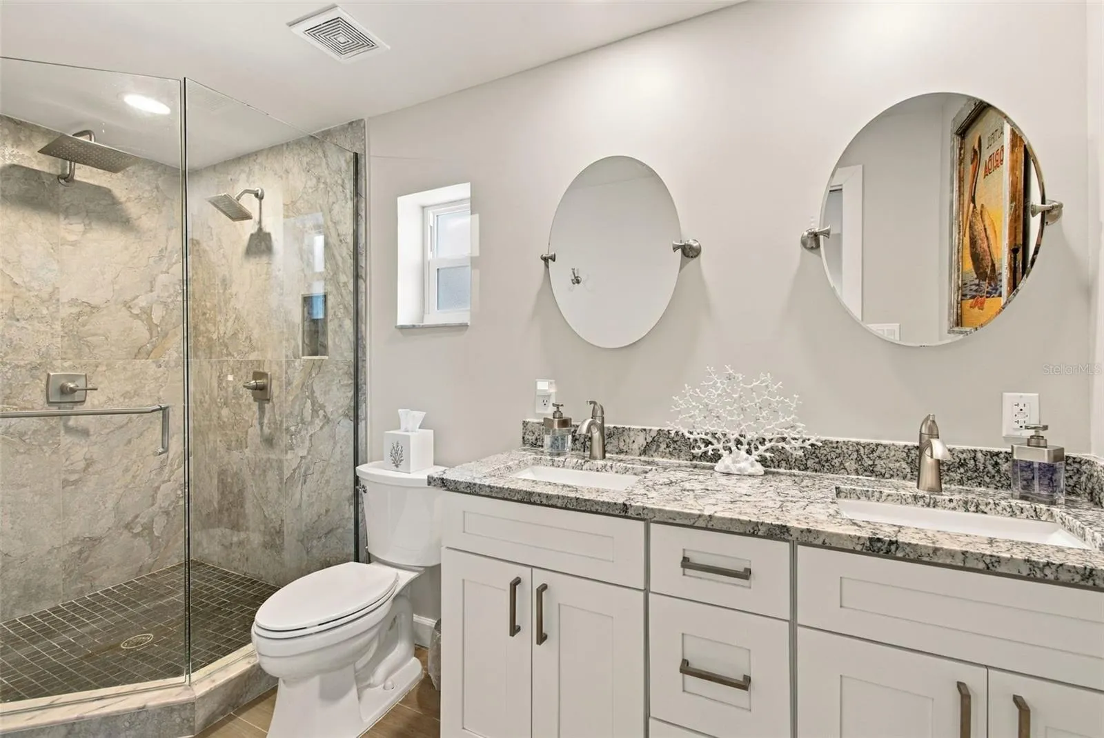 Roomy primary bath with double sink vanity and glass shower with double shower fixtures