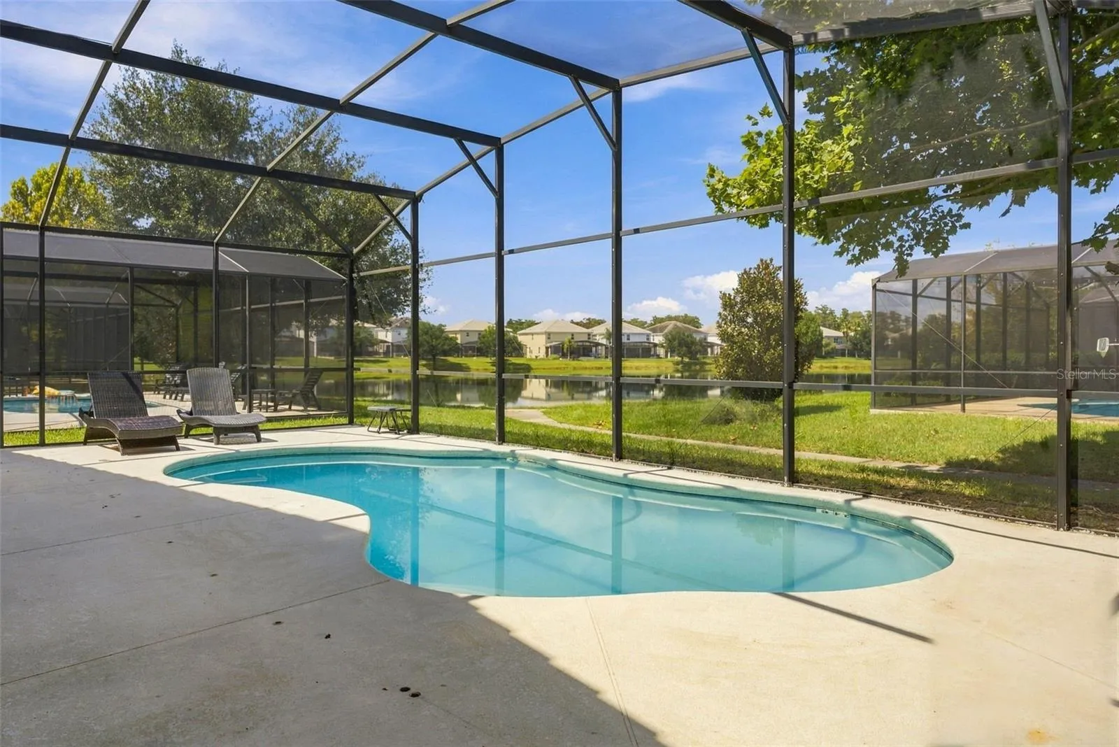 Screened-in sparkling pool overlooking the pond.