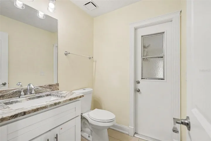 Downstairs half bath with door to the backyard