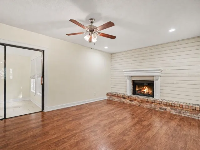 Open family room with wood burning fireplace and shiplap wall