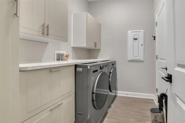 Laundry room with custom cabinetry - smart washer and dryer included
