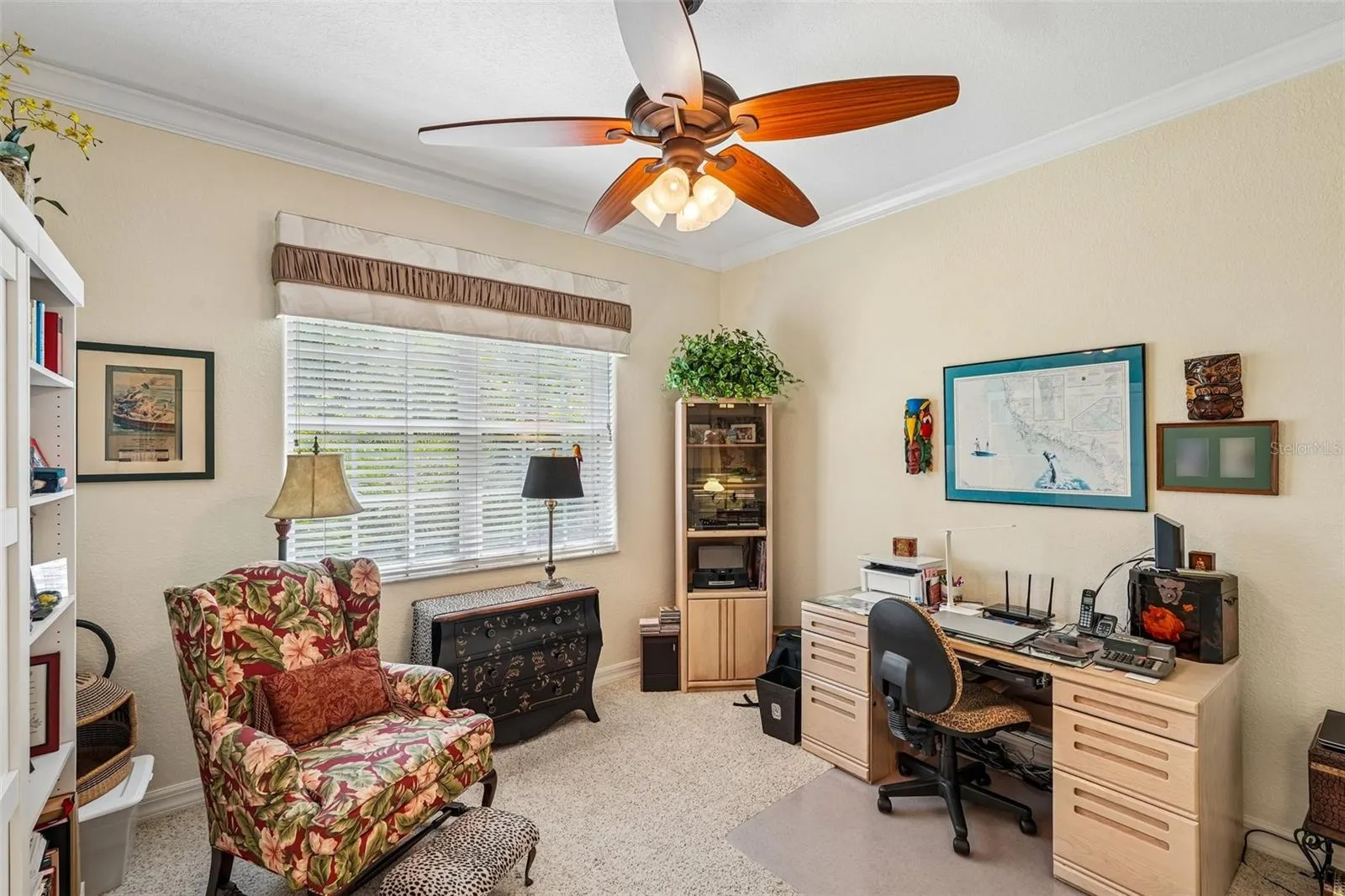 Versatile home office or guest bedroom featuring plush carpeting, Murphy Bed, crown molding, a wood-blade ceiling fan and a large window providing ample natural light