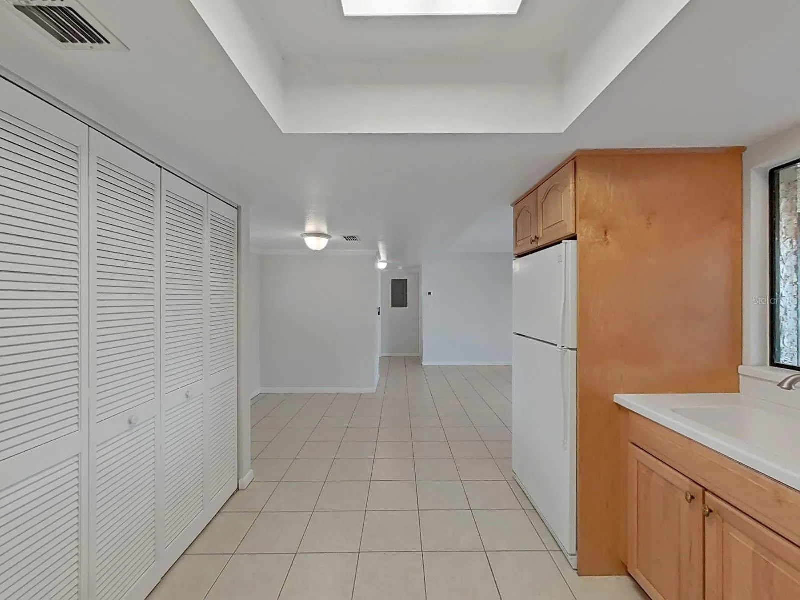 KITCHEN LOOKS TOWARDS THE HALLWAY, LEADING TO BEDROOM AND 2 BATHROOMS.