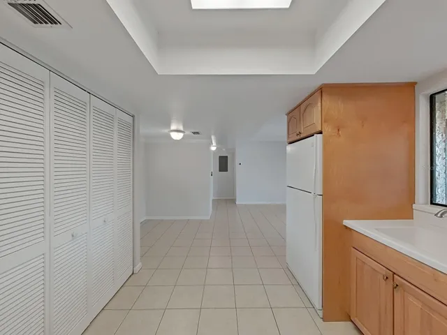 KITCHEN LOOKS TOWARDS THE HALLWAY, LEADING TO BEDROOM AND 2 BATHROOMS.