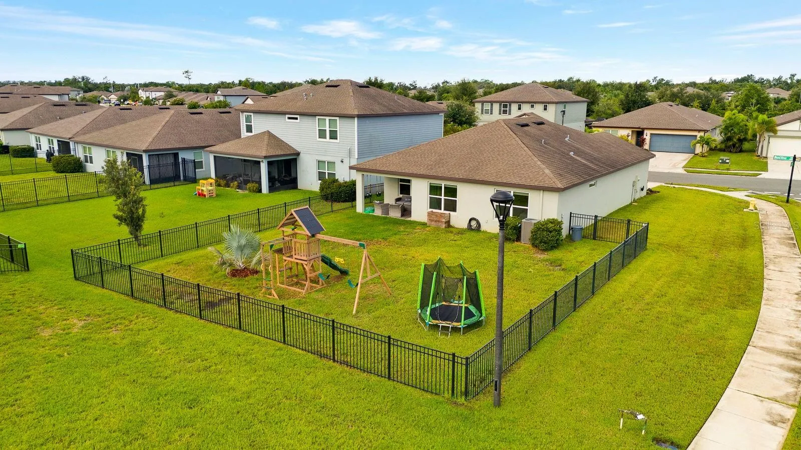Aerial view of large corner lot and fenced yard