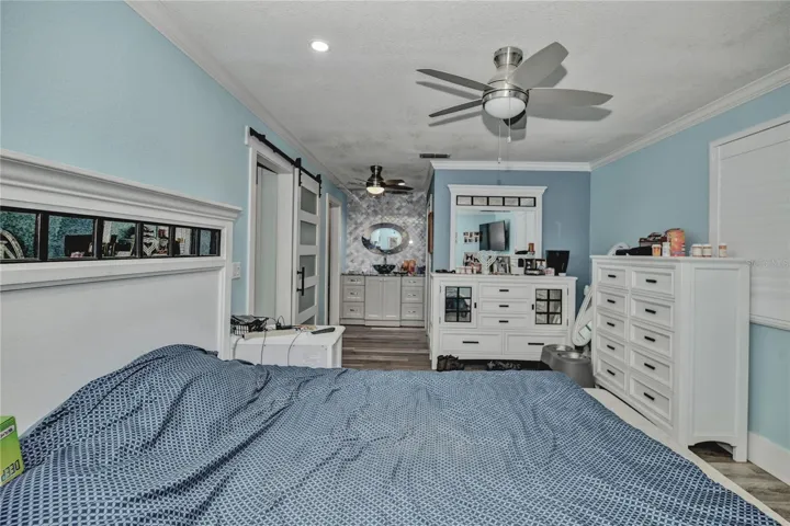 Primary bedroom barn door, high ceiling ceiling fan