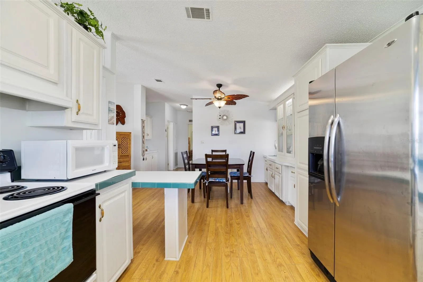 The Kitchen is designed for both everyday living and entertaining, featuring crisp WHITE CABINETRY, plenty of storage and a convenient BREAKFAST BAR.