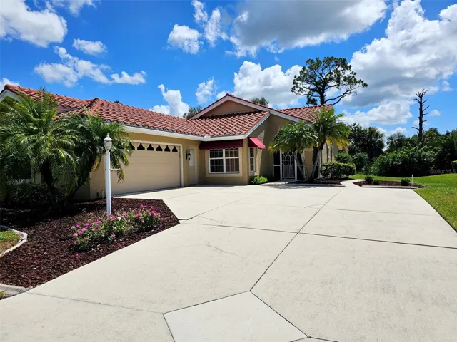 Front of the house with a long driveway and side entry garage