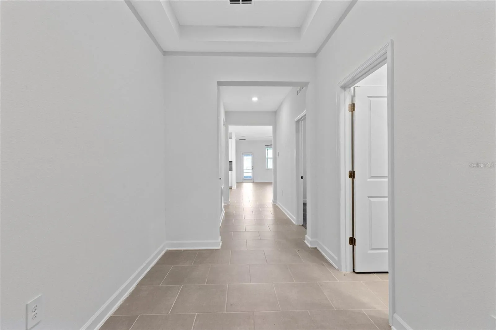 Step inside to a light and welcoming interior featuring high ceilings, a fresh neutral palette and ceramic tile throughout the main living areas.