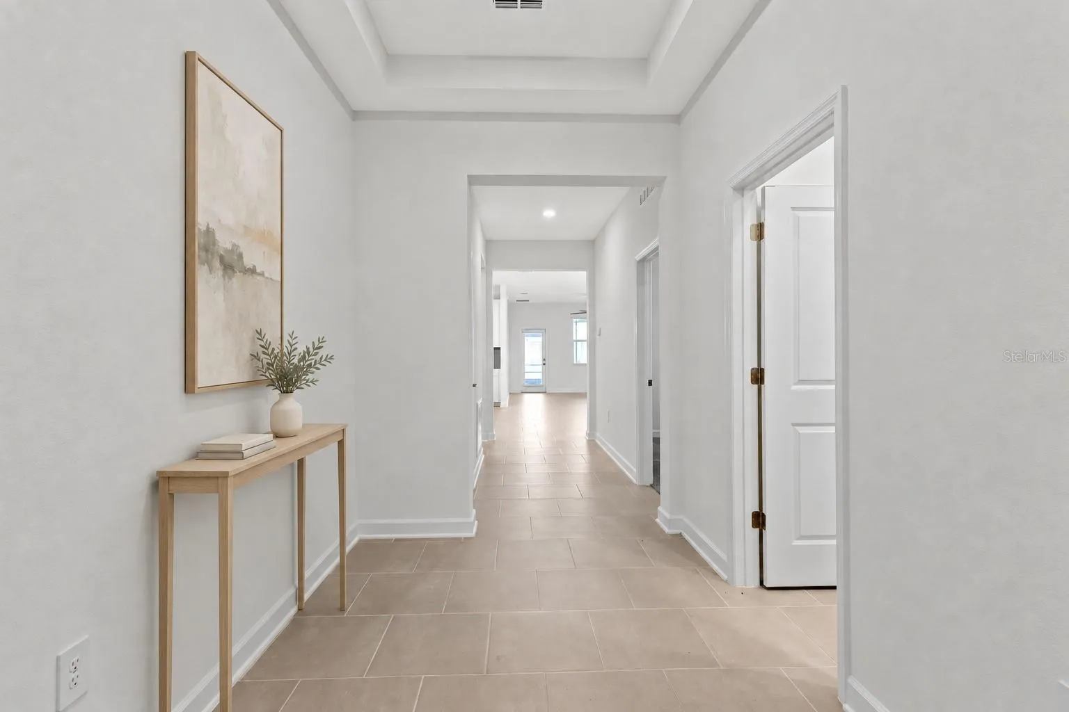 Step inside to a light and welcoming interior featuring high ceilings, a fresh neutral palette and ceramic tile throughout the main living areas.